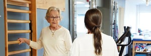 Physical therapist guiding an older adult through functional movement to support healthy aging and long-term mobility.