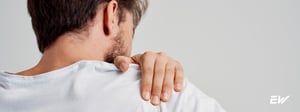 Man holding his shoulder due to shoulder pain, representing common shoulder conditions treated with physical therapy to improve strength, mobility, and reduce pain.