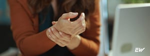 Person experiencing wrist pain associated with carpal tunnel syndrome, commonly treated with physical therapy.