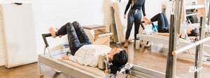 Person performing pilates for diastasis recti while lying on a reformer-style pilates table.