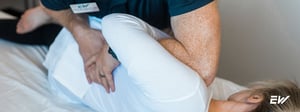 Physical therapist performing a hip assessment to evaluate hip impingement and movement restrictions.