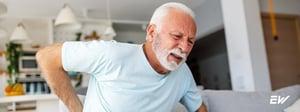 Older adult holding their lower back, representing pain associated with nerve compression.