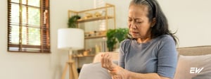 Adult holding their wrist and hand, representing pain and discomfort associated with neuropathy.”