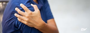 Person holding shoulder due to shoulder labral tear pain, a condition treated with physical therapy.