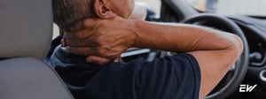 Driver experiencing neck pain associated with whiplash injury, commonly evaluated and treated through physical therapy.