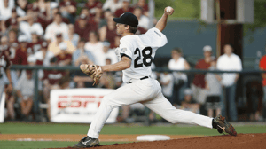 A pitcher winds up to throw a baseball.