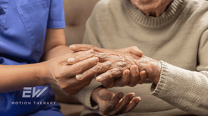 An older woman examines her hands.