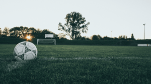 A soccer ball sits on an empty field.