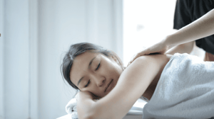 A woman lies on her stomach on a massage table.