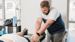 A man massages a person's leg.