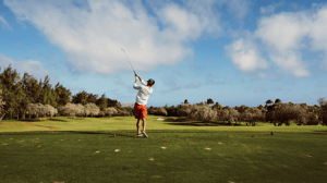 A man hits on a golf course.