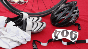 A flat lay of triathlon equipment, including a bike helmet and running shoes.