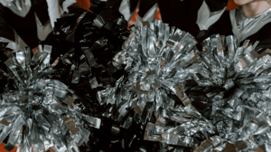 A cheer squad holds their pom-poms.