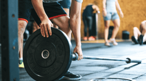 A man puts a weight on a barbell.