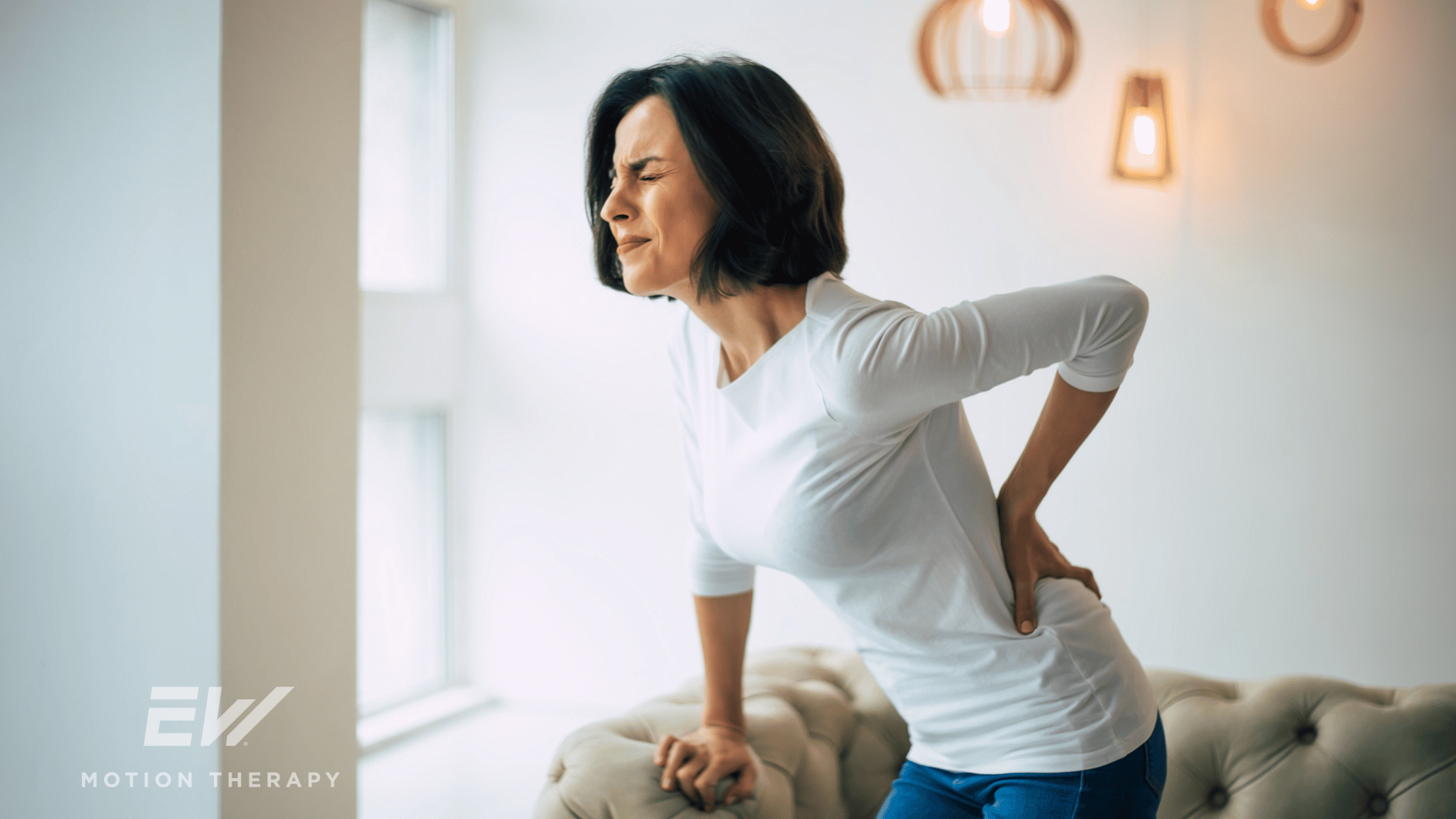 A woman bends over with lower back pain.