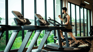 A man runs on a treadmill in a gym.