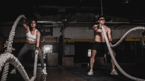 Two people work out in a CrossFit-like facility.