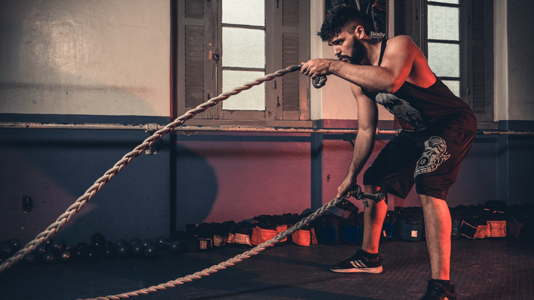 A man swings ropes at the gym