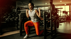 A woman lifts a barbell.
