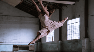 A leaping contemporary dancer in a pink dress