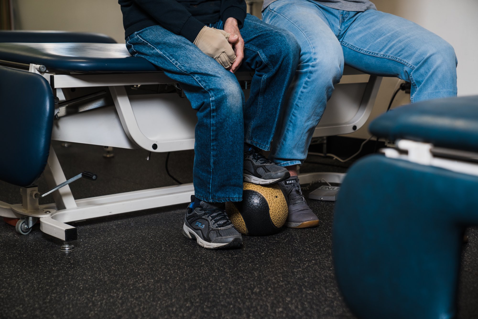 A patient sits while rolling his foot over a ball in specialized exercises for neurological therapy. A patient sits while rolling his foot over a ball in specialized exercises for neurological therapy.