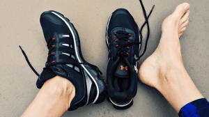 From above, feet with one foot out of a shoe.