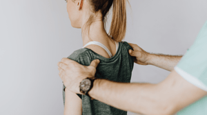 A man holds a woman's shoulders from behind.
