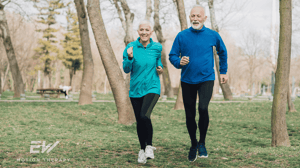 An elderly couple walks outside together.