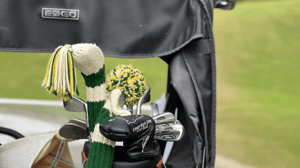 A set of golf clubs on the back of a golf cart. 