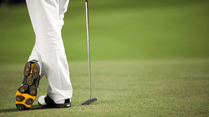 A golfer crosses his feet.
