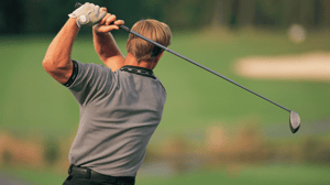 A golfer swings back after a long shot.