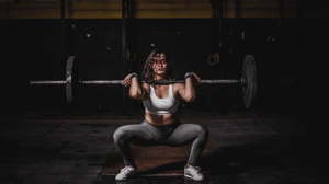 A woman lifts a barbell.
