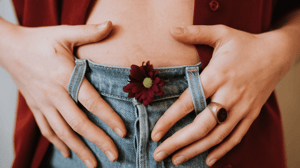 A woman puts her hands on her lower abdomen