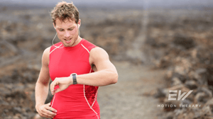 A man looks down at his fitness tracker on his wrist.