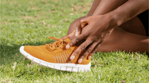 A person holding their ankle.