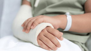An arm in a cast resting on a pillow.