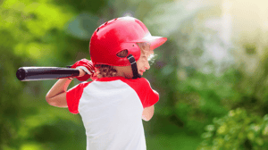 A young boy swings a baseball bat.
