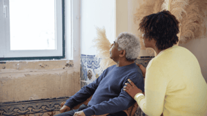 Two people look out a window.
