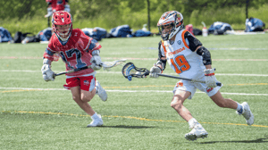 Two young boys play lacrosse.