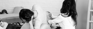 A woman gives another woman a mid-back massage. 