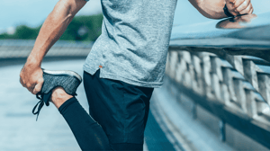 A man stretching his leg before going for a jog