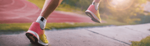 Feet running on a sidewalk.