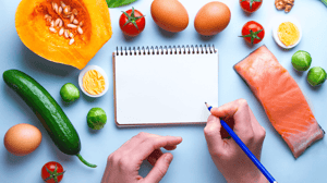 A person writing in journal about a balanced healthy diet