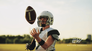 A football player tosses a ball in the air.