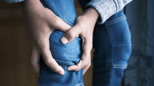 A person clutches their knee.