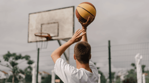 A man outside about to shoot a basketball