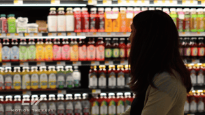 A woman browses drinks in a grocery store.