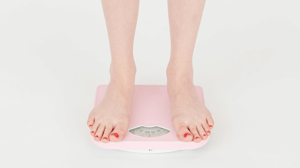 Feet standing on a pink scale