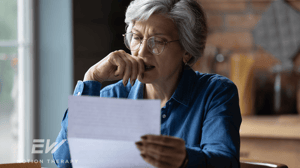 An older woman reads a letter.