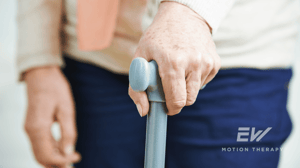 Close-up of an old woman's hand holding a cane.
